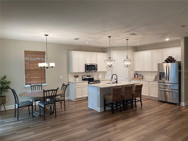 kitchen with dark wood-type flooring, stainless steel appliances, and white cabinets