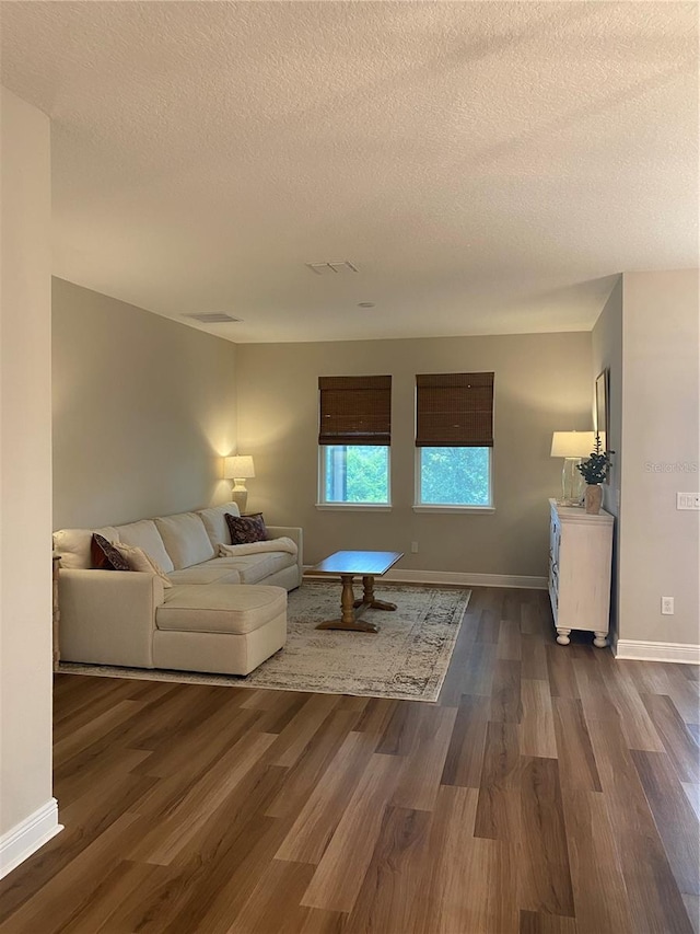 living room featuring dark hardwood / wood-style floors and a textured ceiling