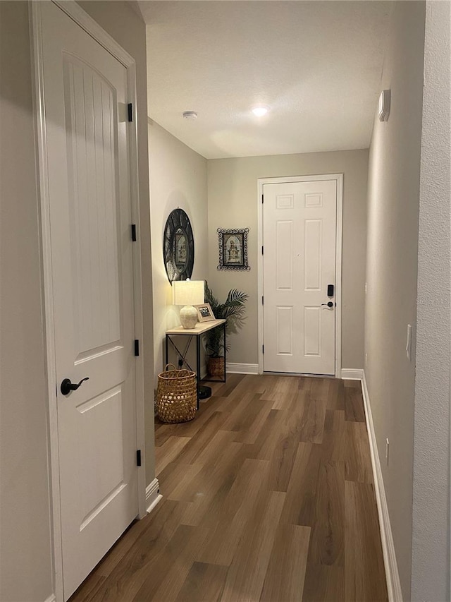 corridor with wood finished floors and baseboards