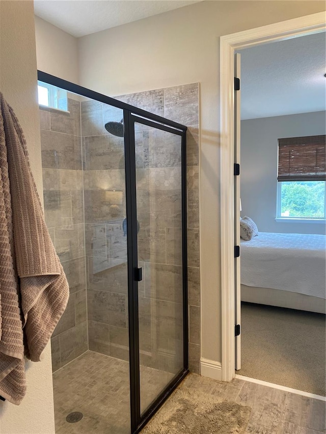 bathroom with a shower with door and a healthy amount of sunlight