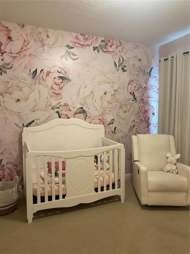 bedroom featuring a textured ceiling, wallpapered walls, and carpet