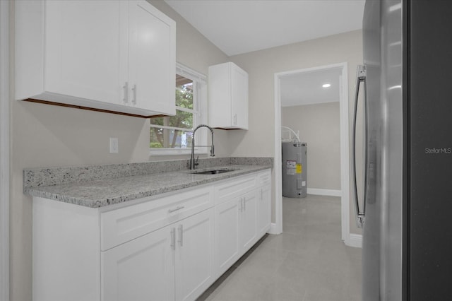 kitchen with stainless steel fridge, water heater, sink, and white cabinets