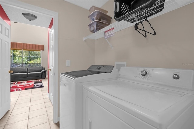 laundry area with separate washer and dryer and light tile patterned floors