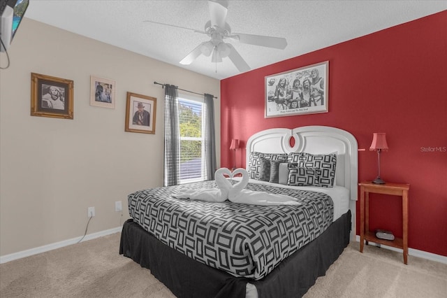 carpeted bedroom featuring ceiling fan and a textured ceiling