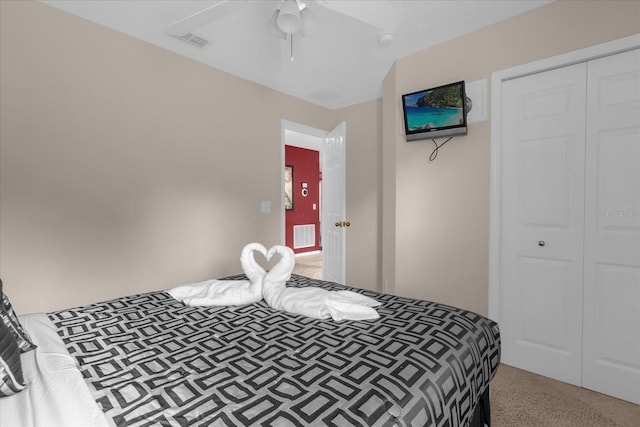 carpeted bedroom with ceiling fan and a closet