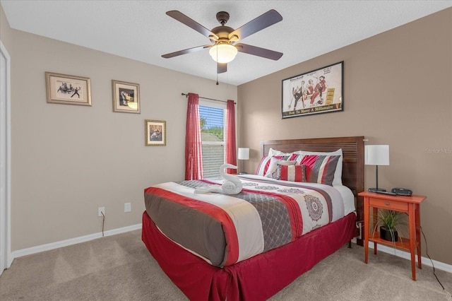 carpeted bedroom with ceiling fan and a textured ceiling