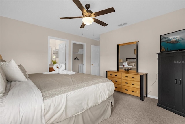 bedroom featuring light carpet, connected bathroom, and ceiling fan