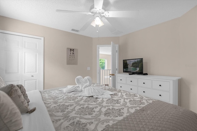 bedroom with a textured ceiling, ceiling fan, and a closet