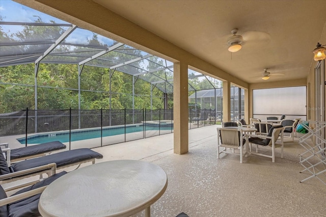 view of patio with glass enclosure, a fenced in pool, and ceiling fan