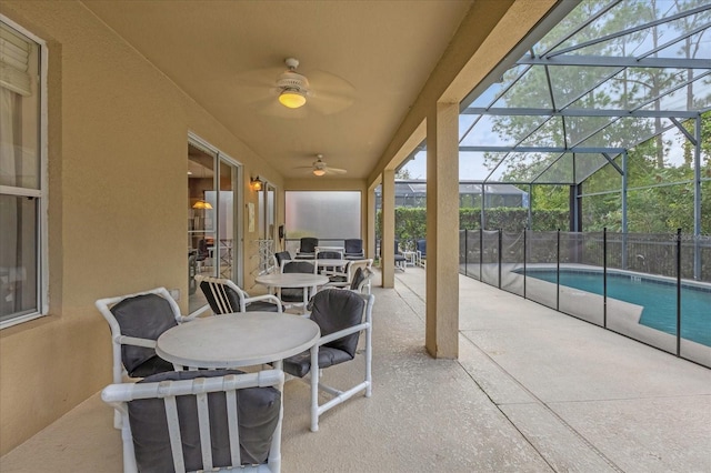 view of patio / terrace with glass enclosure, a fenced in pool, and ceiling fan