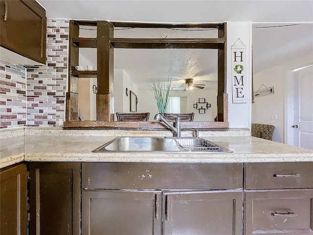 kitchen with tasteful backsplash, kitchen peninsula, sink, and ceiling fan