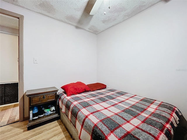 bedroom featuring a textured ceiling, ceiling fan, and light hardwood / wood-style floors