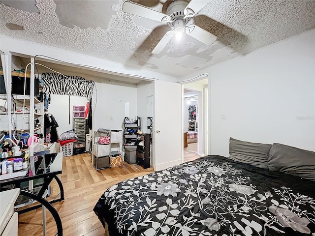 bedroom featuring hardwood / wood-style floors, ceiling fan, and a textured ceiling