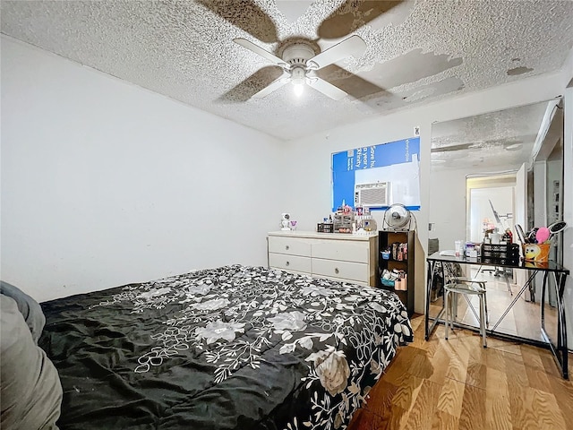 bedroom featuring a textured ceiling, ceiling fan, and light hardwood / wood-style floors