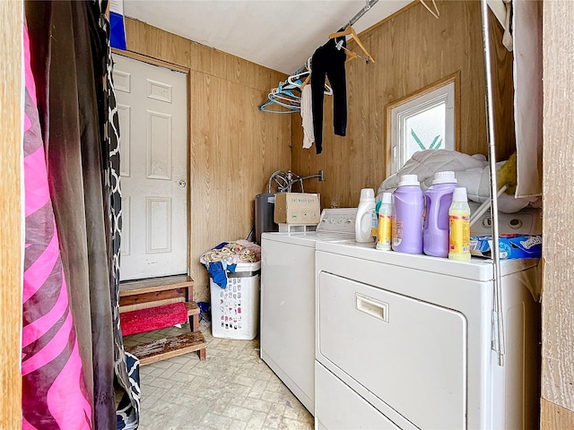 washroom with wooden walls and washing machine and clothes dryer