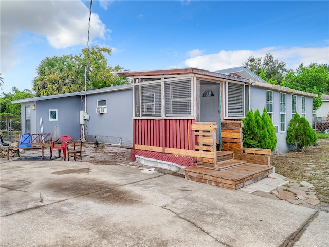 manufactured / mobile home with an AC wall unit and a patio