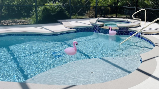 view of swimming pool with a lanai and an in ground hot tub