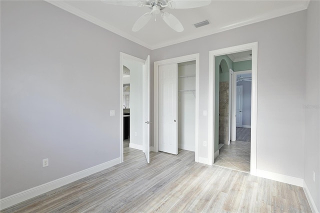 unfurnished bedroom featuring ceiling fan, a closet, ornamental molding, and light hardwood / wood-style flooring