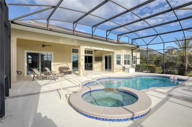 view of swimming pool featuring an in ground hot tub, glass enclosure, ceiling fan, and a patio area