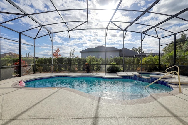 view of pool with an in ground hot tub, glass enclosure, and a patio area