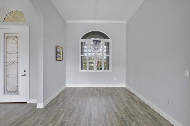 entrance foyer featuring a chandelier, ornamental molding, and light hardwood / wood-style flooring