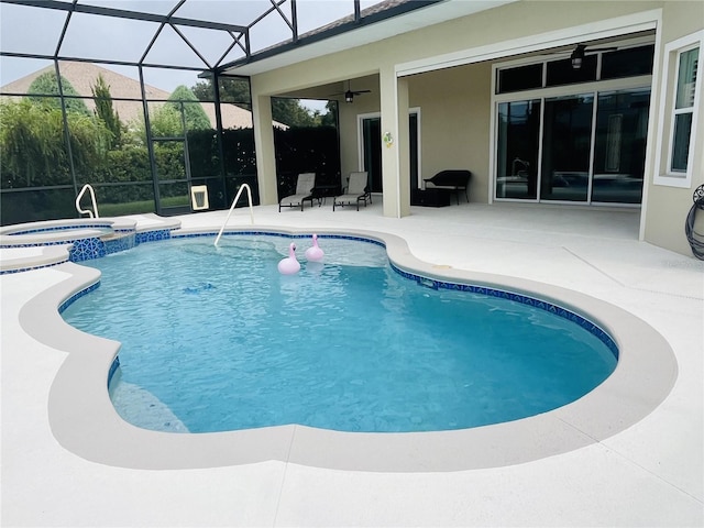 view of pool with a lanai, an in ground hot tub, ceiling fan, and a patio