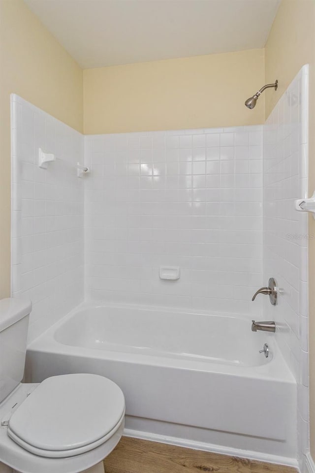 bathroom featuring hardwood / wood-style floors, shower / bathtub combination, and toilet