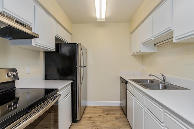 kitchen with extractor fan, light wood-type flooring, stainless steel appliances, and white cabinetry