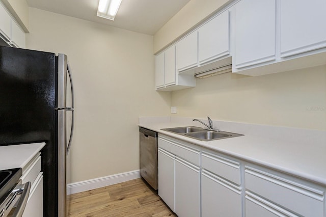 kitchen with white cabinets, stainless steel appliances, light hardwood / wood-style flooring, and sink