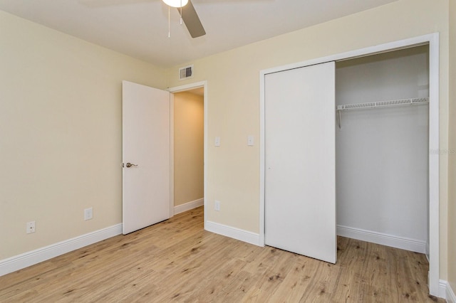 unfurnished bedroom featuring ceiling fan, a closet, and light wood-type flooring