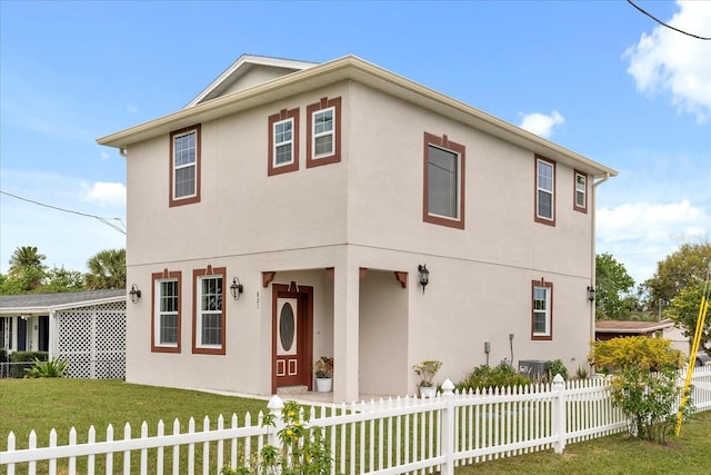 view of front of home featuring a fenced front yard, a front lawn, and stucco siding