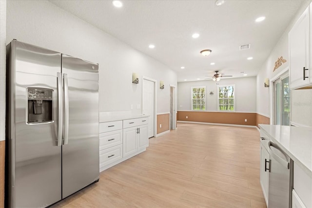 kitchen featuring white cabinetry, visible vents, appliances with stainless steel finishes, and light wood finished floors