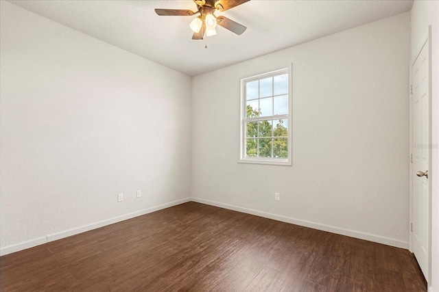 empty room featuring dark wood-style floors, baseboards, and a ceiling fan