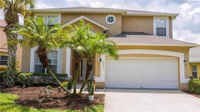 mediterranean / spanish home with a garage, a shingled roof, concrete driveway, and stucco siding