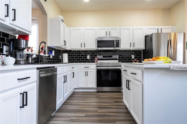 kitchen with decorative backsplash, stainless steel appliances, white cabinets, and dark hardwood / wood-style floors