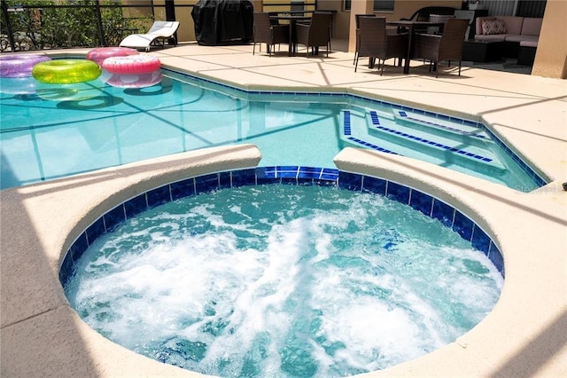 view of pool with grilling area, a patio, and an in ground hot tub