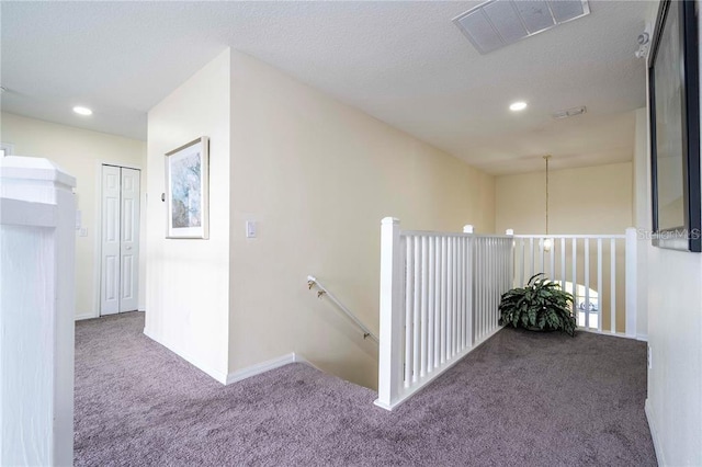 corridor with recessed lighting, visible vents, an upstairs landing, carpet floors, and baseboards