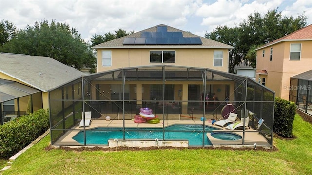 back of house featuring solar panels, a yard, glass enclosure, and a pool with hot tub