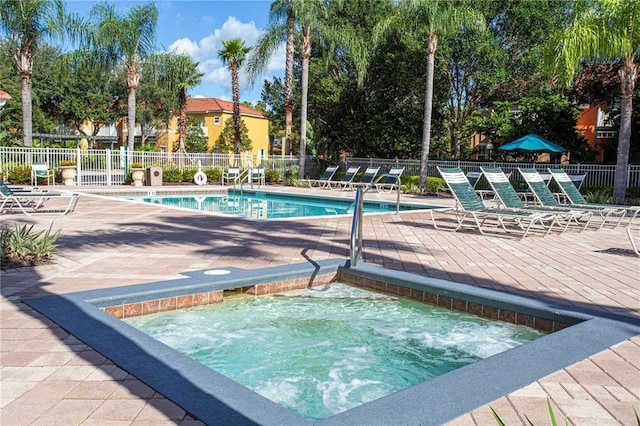 view of swimming pool featuring a patio and a hot tub