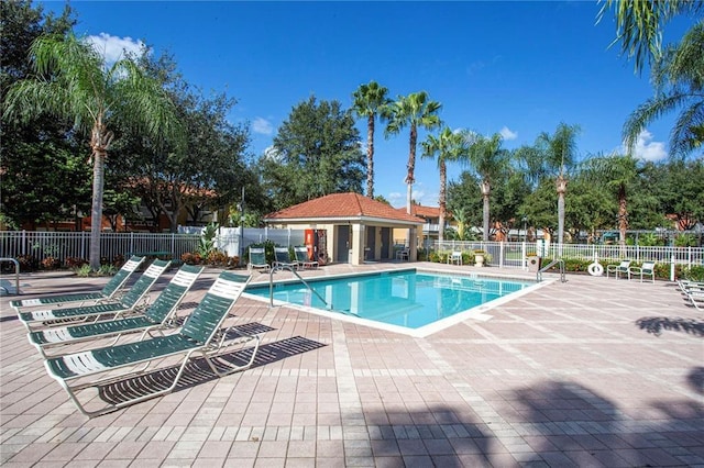 community pool with a patio and fence