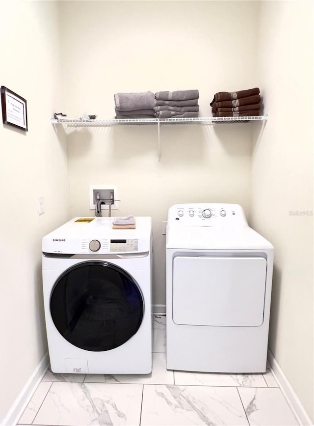 laundry room with independent washer and dryer, laundry area, baseboards, and marble finish floor