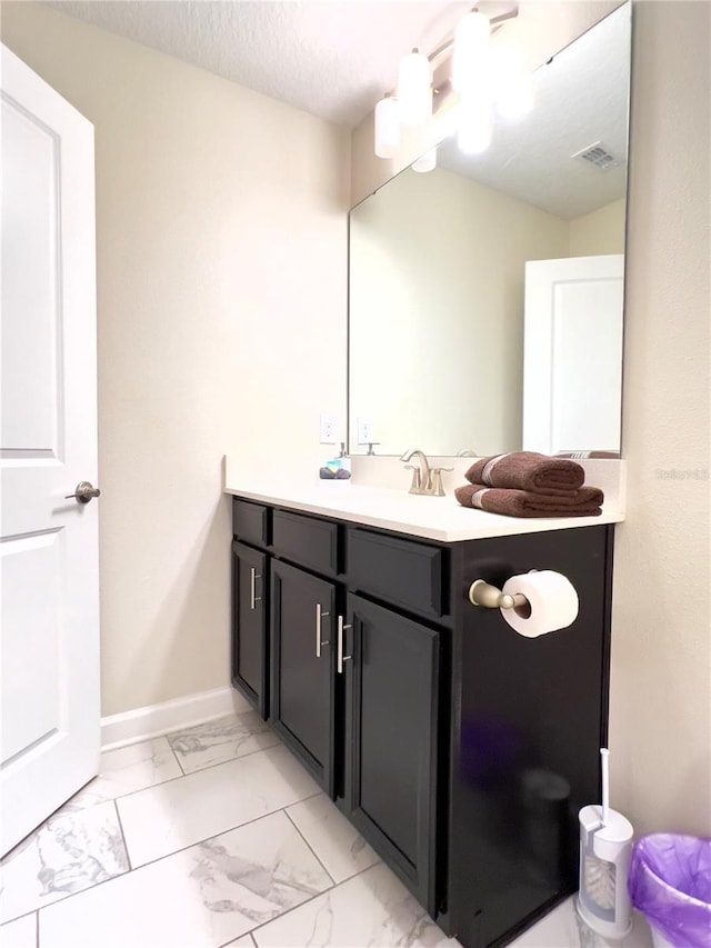 bathroom with a textured ceiling and vanity