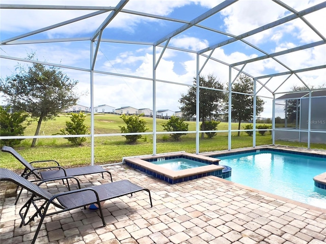 view of swimming pool featuring a lanai, a yard, a patio area, and a pool with connected hot tub