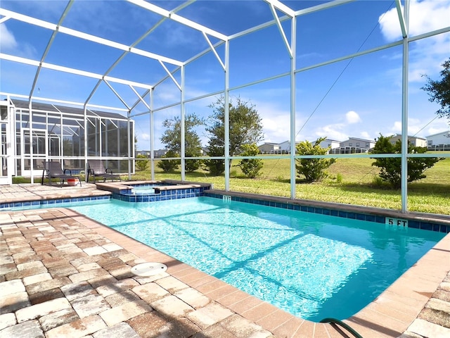 view of pool with glass enclosure, a patio, a lawn, and an in ground hot tub