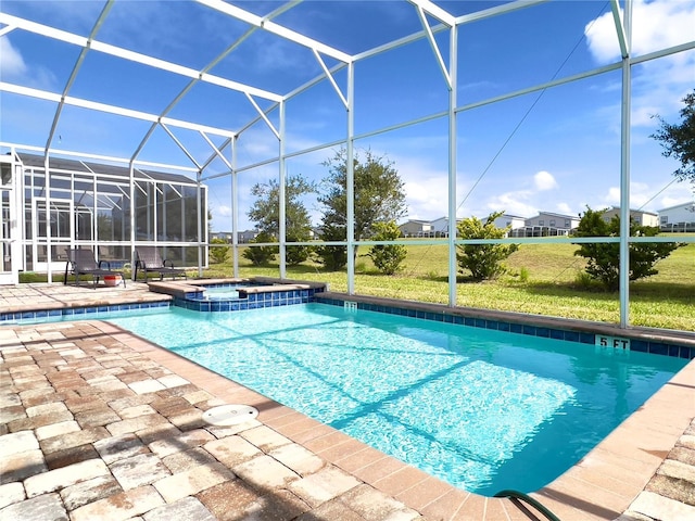 view of swimming pool featuring glass enclosure, a patio area, and a pool with connected hot tub