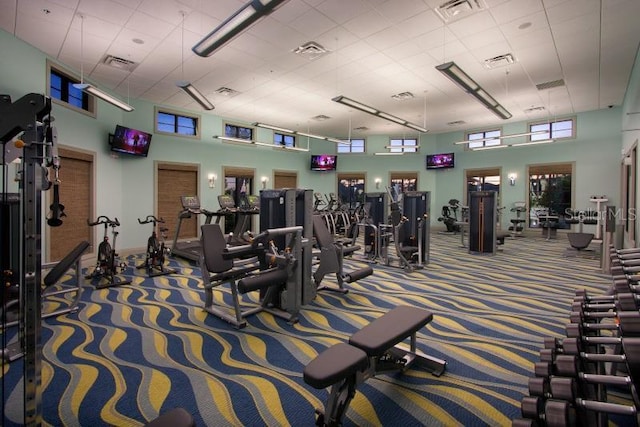 exercise room featuring a high ceiling, carpet flooring, and visible vents