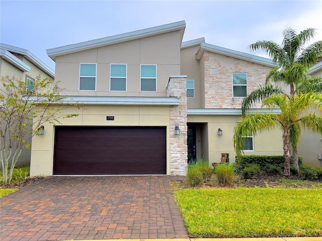 791 Pebble Beach Dr, Davenport, FL 33896 - view of front of property featuring stone siding, an attached garage, decorative driveway, and stucco siding