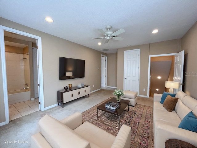 tiled living room featuring ceiling fan and a textured ceiling