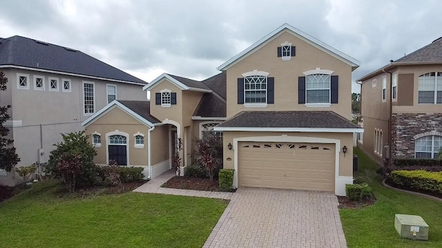 view of property featuring a front lawn and a garage