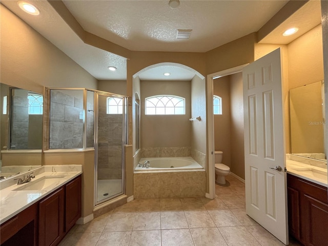 full bathroom with vanity, tile patterned floors, separate shower and tub, toilet, and a textured ceiling